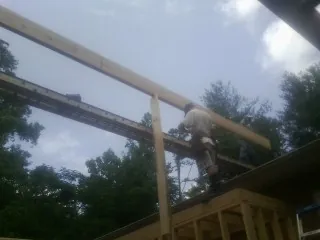 Carpenter setting a ridge beam over a new addition frame — Ice Dam Removal by Roofing Brothers in Bolivar